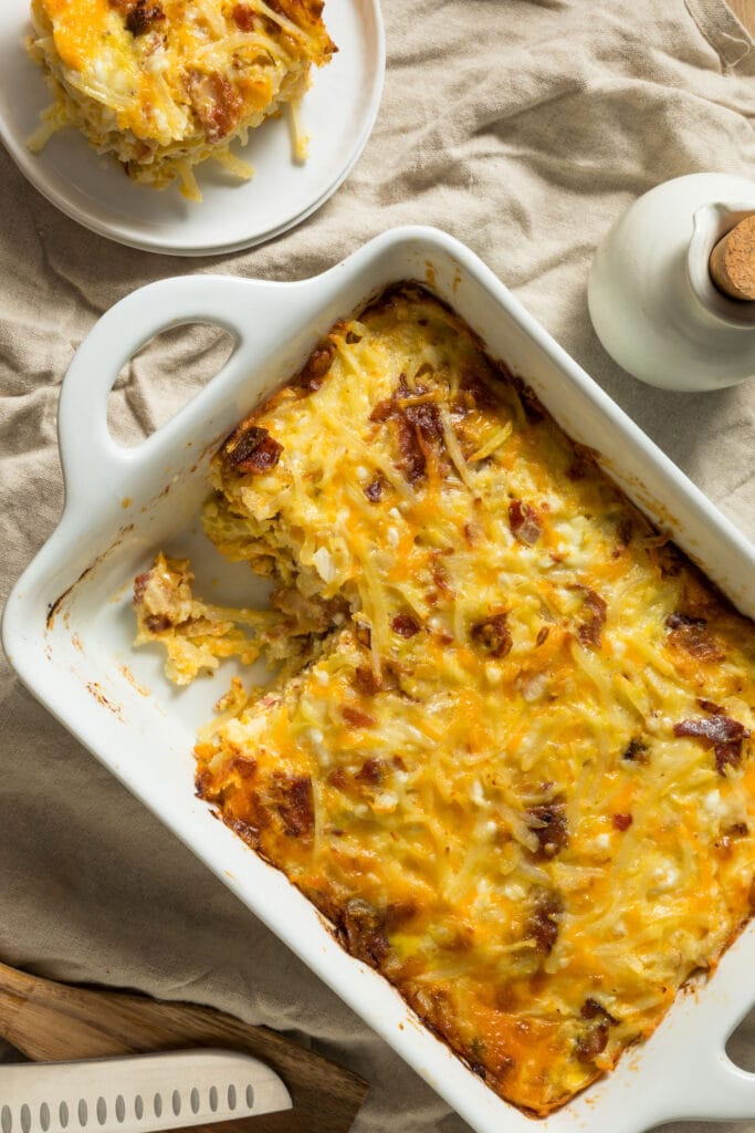 breakfast casserole in baking dish with slice removed and on plate next to it.