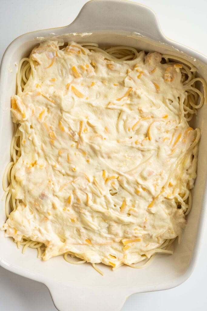 sour cream mixture added to spaghetti in baking dish.