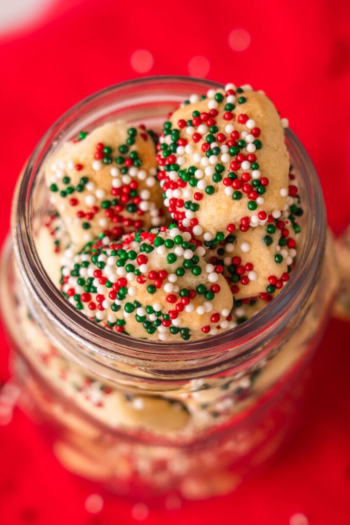 closeup of sprinkle sugar cookies in glass jar. 