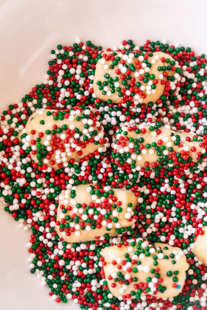 cookies rolled in red, white and green sprinkles in bowl. 