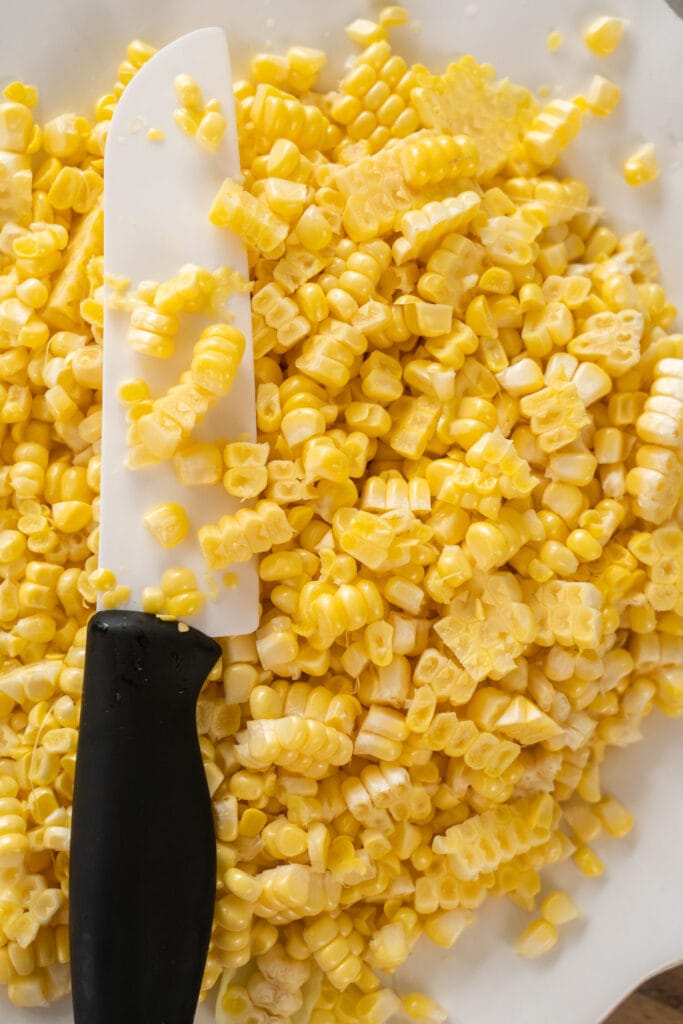fresh corn removed from cob on cutting board.