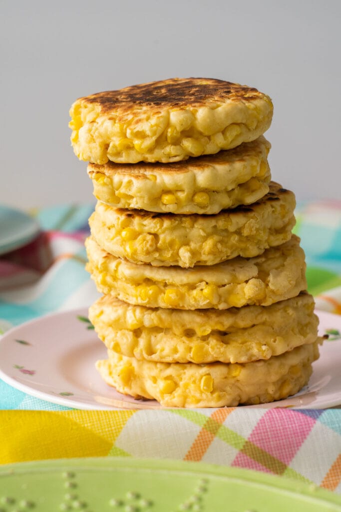 stack of corn pancakes on pink plate.