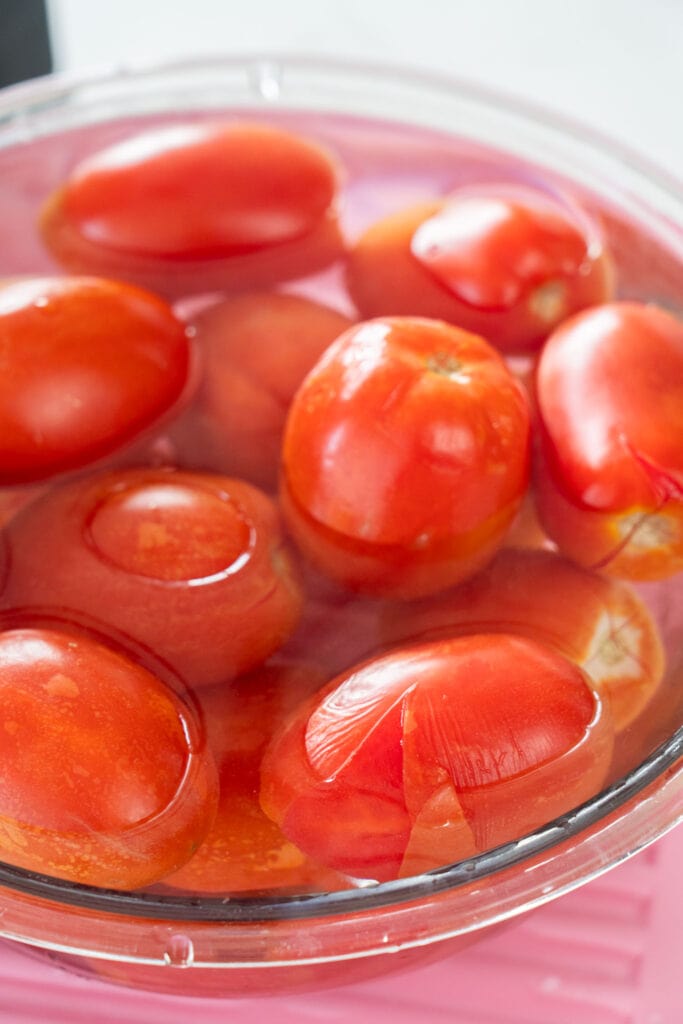 tomatoes peeling in ice bath.