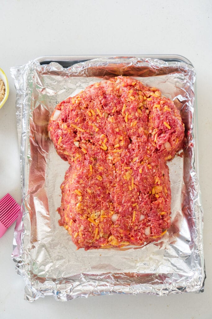 ground beef shaped into zombie head on baking sheet.
