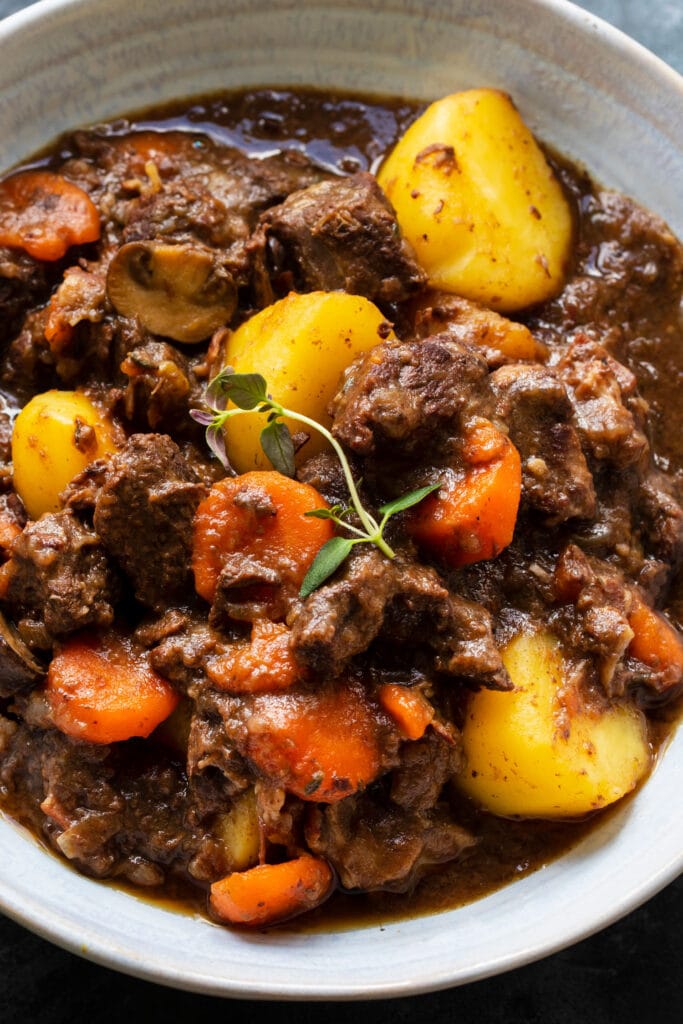 closeup of hearty beef stew with potatoes and carrots in bowl. 