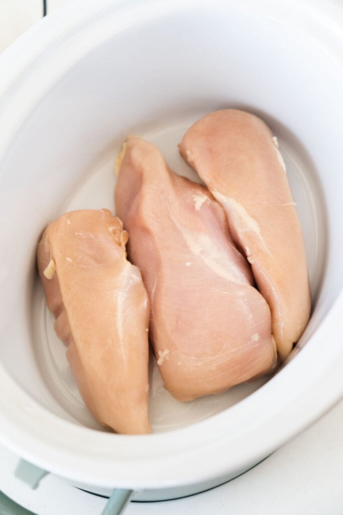 raw chicken breasts in slow cooker.