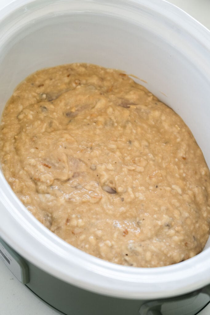 soup mixture poured on top of chicken in slow cooker.