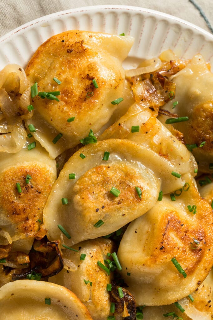 closeup of pierogies and cabbage on plate.