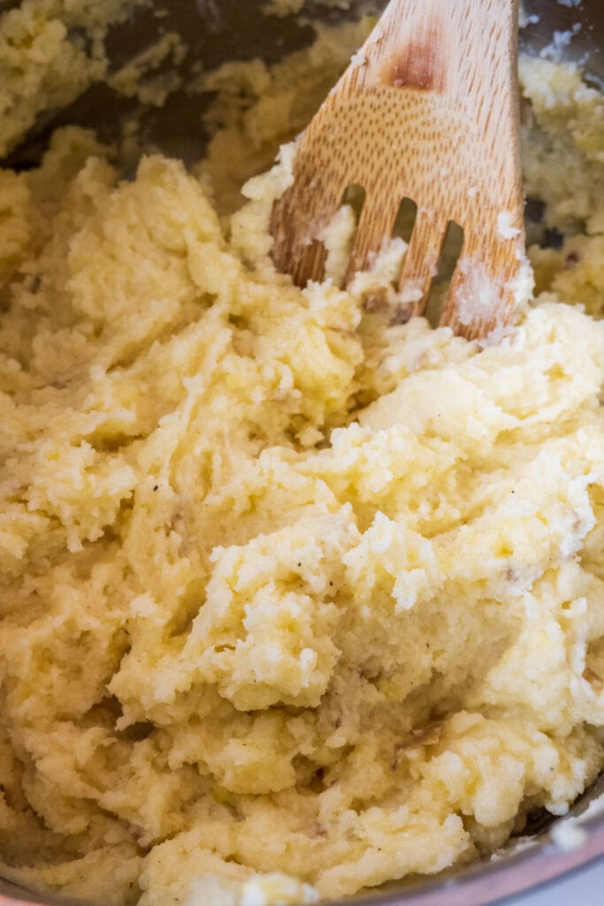 spoon in pot of creamy mashed potatoes.