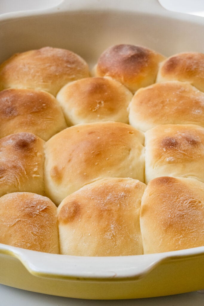 golden brown baked sweet rolls in yellow baking pan.