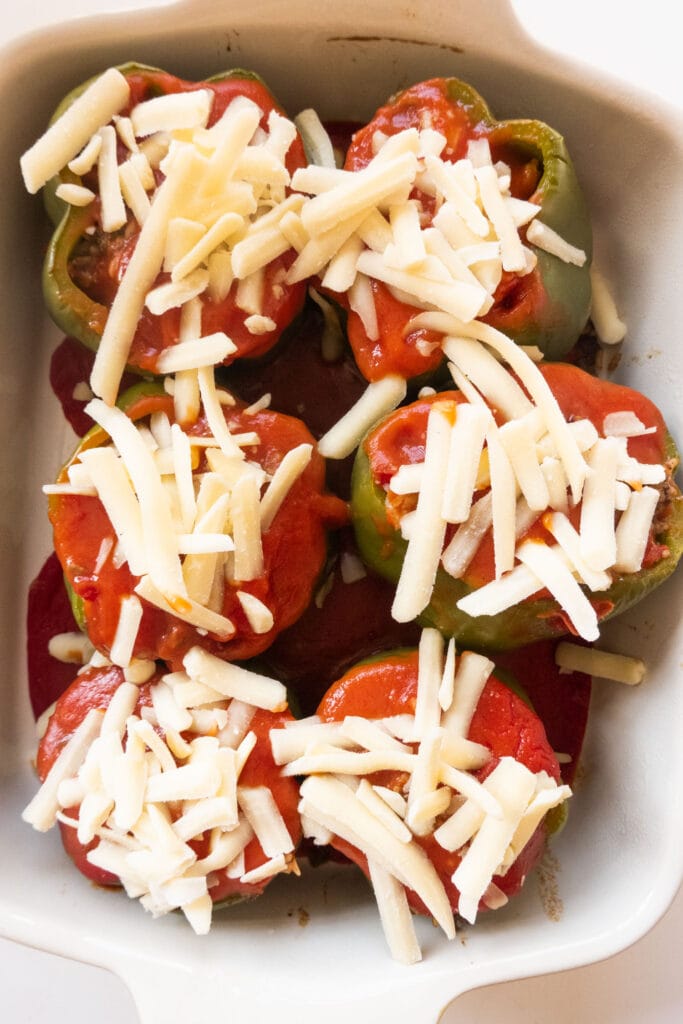 shredded cheese on top of stuffed peppers.