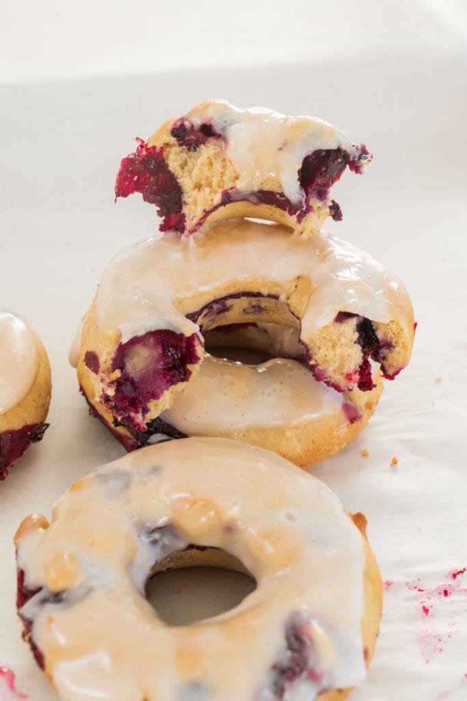 fluffy donuts ripped in half stacked on top of each other on wax paper.