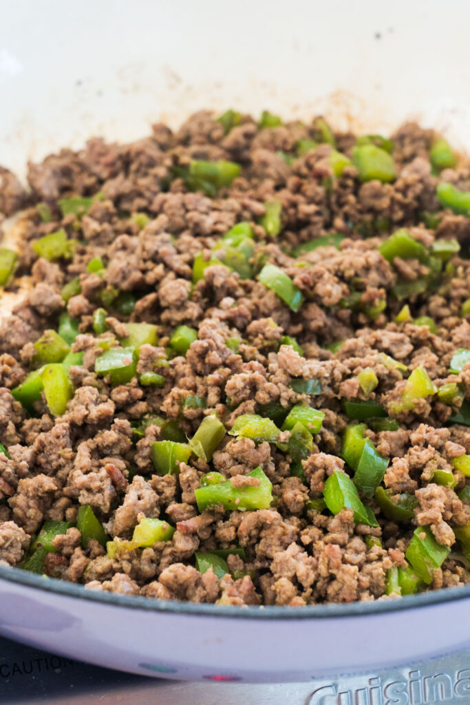 ground beef browned in skillet with green peppers.