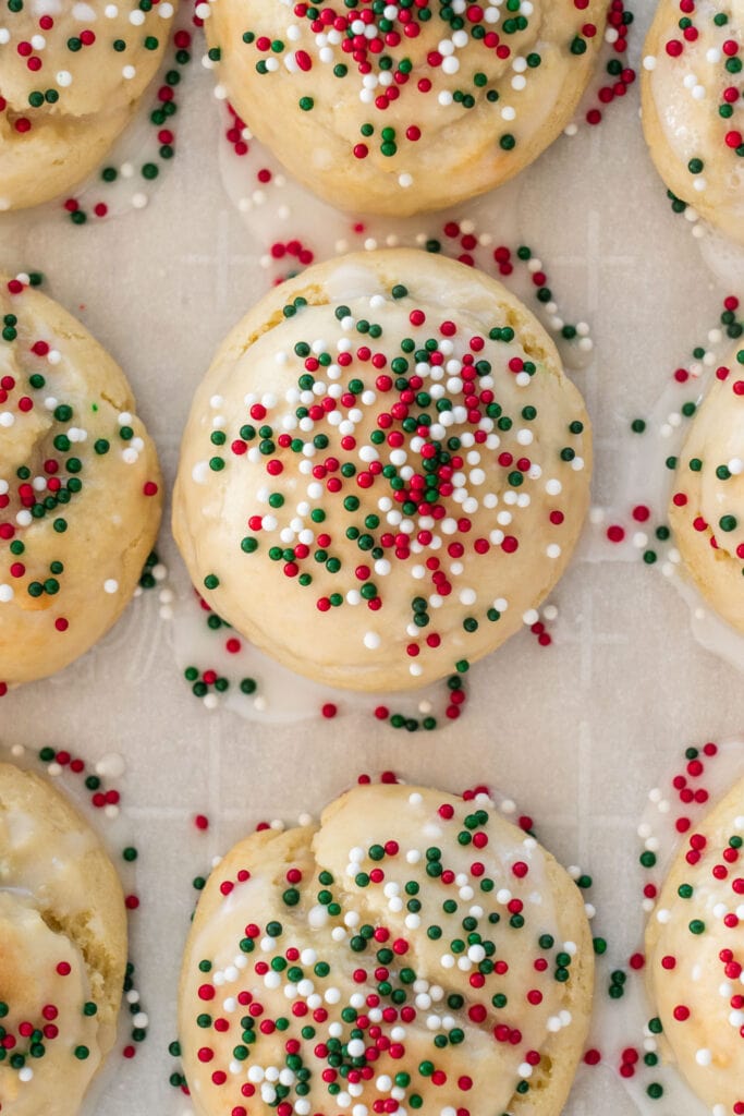 ricotta cookies on parchment paper with christmas sprinkles on top.