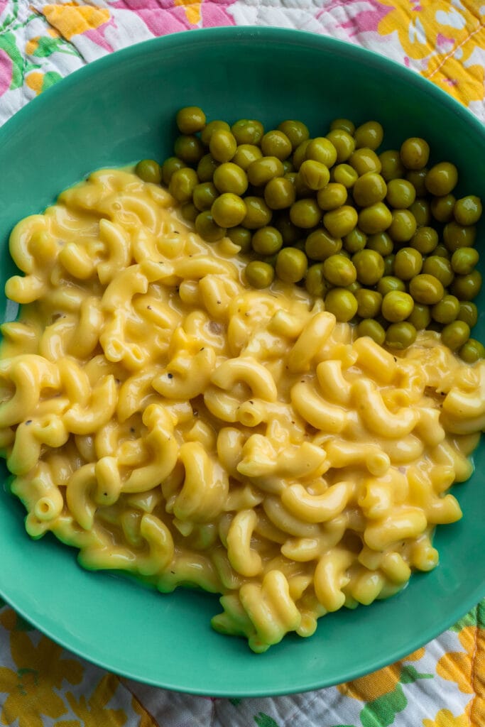 plate with peas and mac and cheese on it.