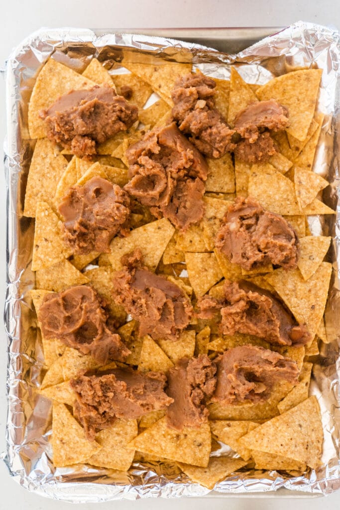 tortilla chips with refried beans on top. 