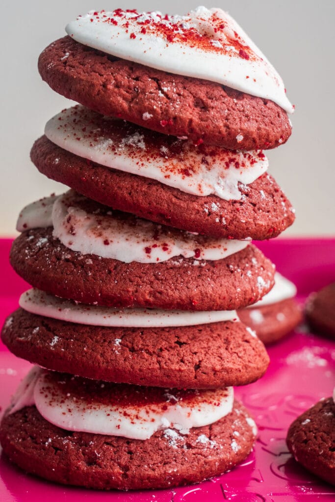 stack of red velvet cookies with frosting on top.