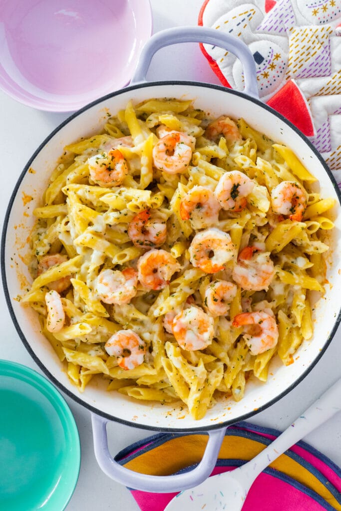 skillet filled with cheesy shrimp and pasta on table.