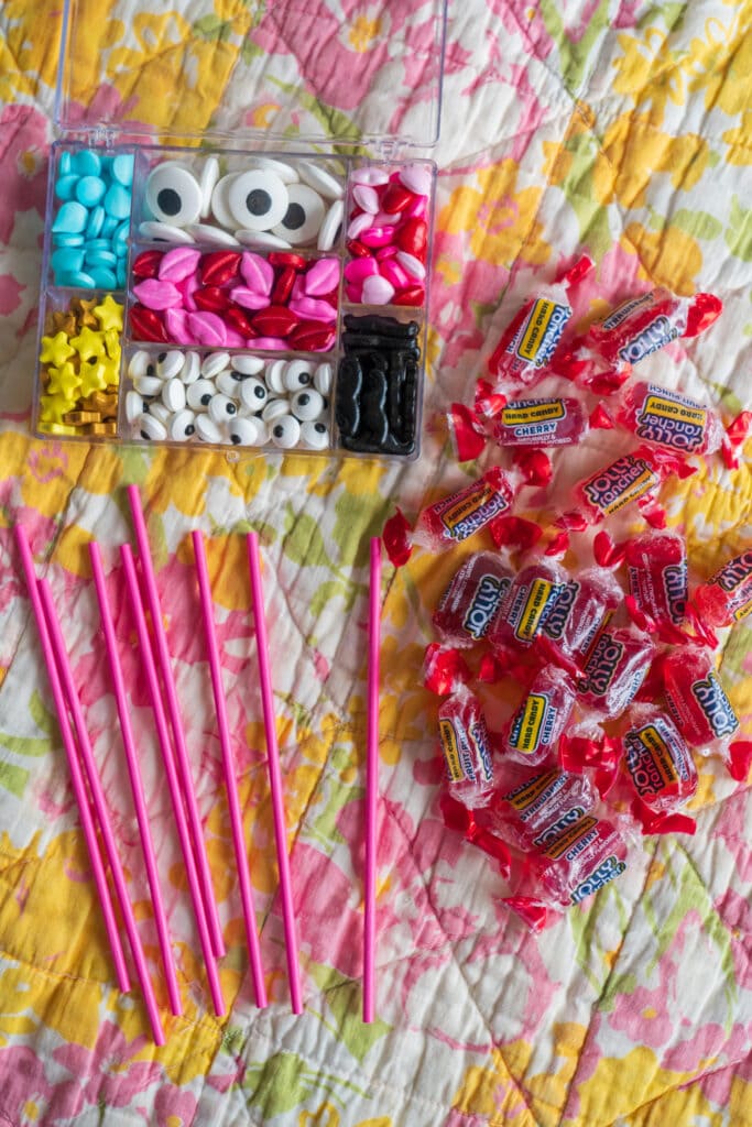 supplies to make monster lollipops on quilted table top.