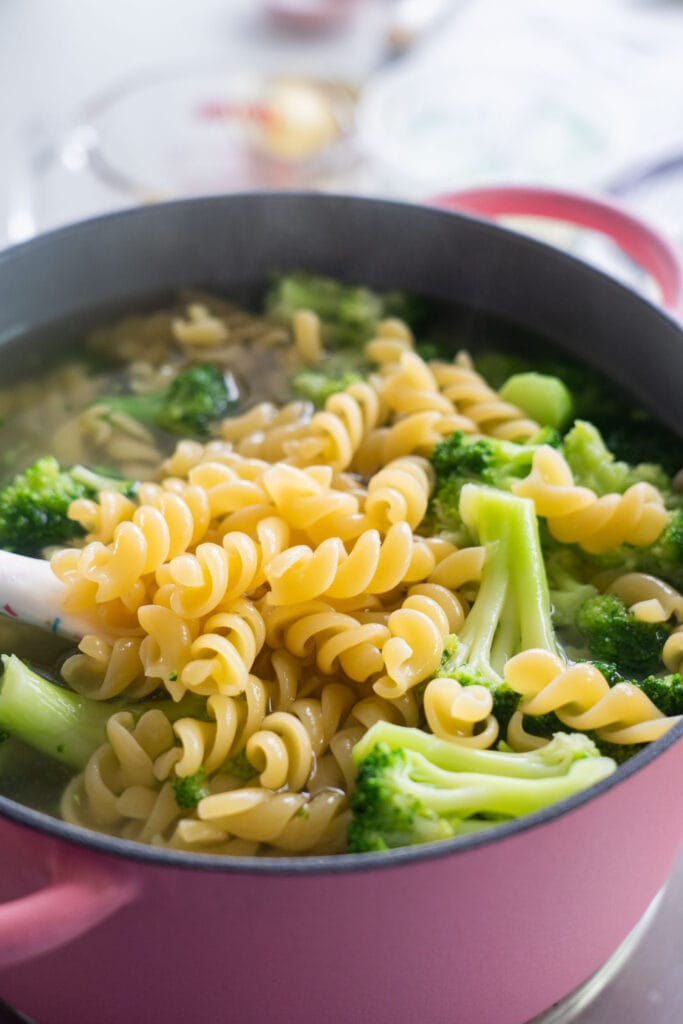 pasta and broccoli in a pot of water.