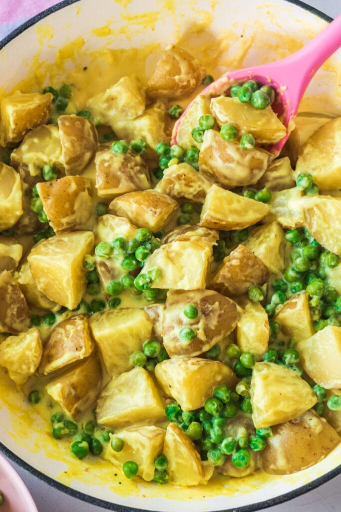creamy potatoes and peas in skillet, ready to be served. 