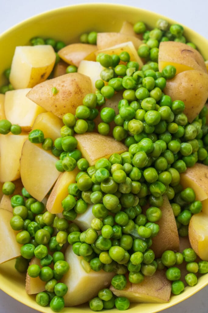 cooked potatoes and peas in bowl.