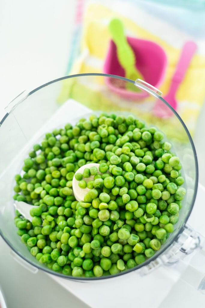 peas in food processor waiting to be pulsed.