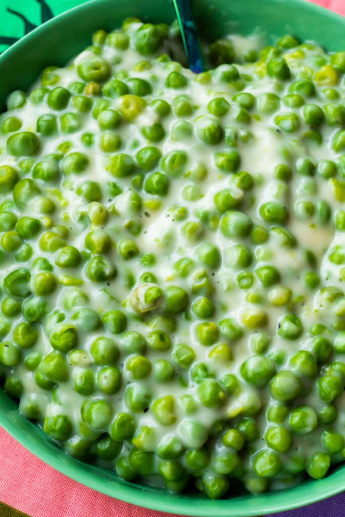 peas with cream sauce in green bowl. 