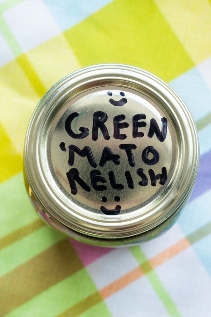 lid of mason jar with written words green mato relish on top.