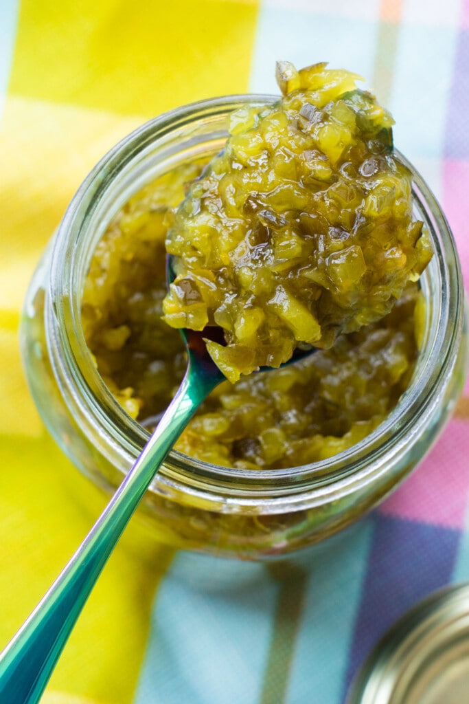 spoon dipping into mason jar filled with green tomato relish.