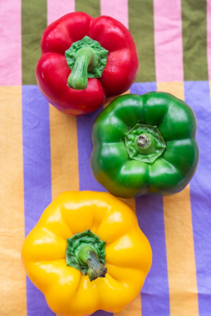 3 bell peppers on printed table cloth.