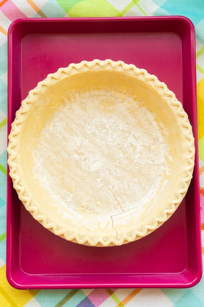  pie crust on top of pink baking sheet.
