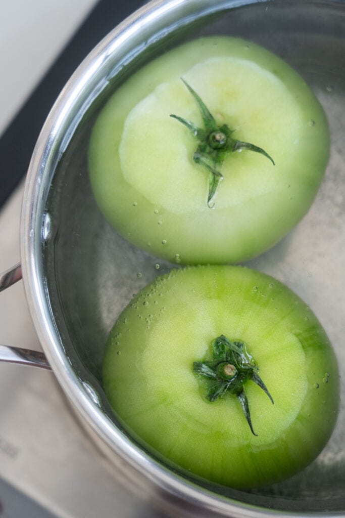 green tomatoes boiling in pot.