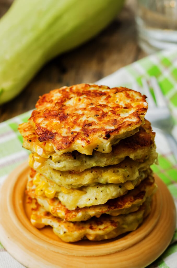 stack of zucchini fritters on plate on table.