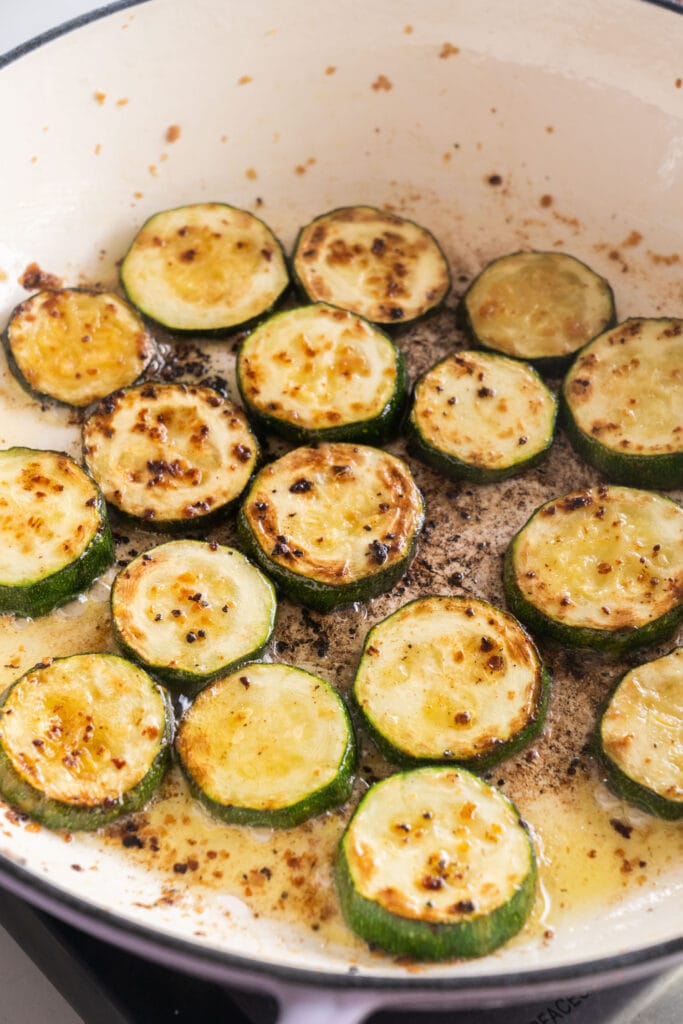 browned zucchini slices in purple skillet.