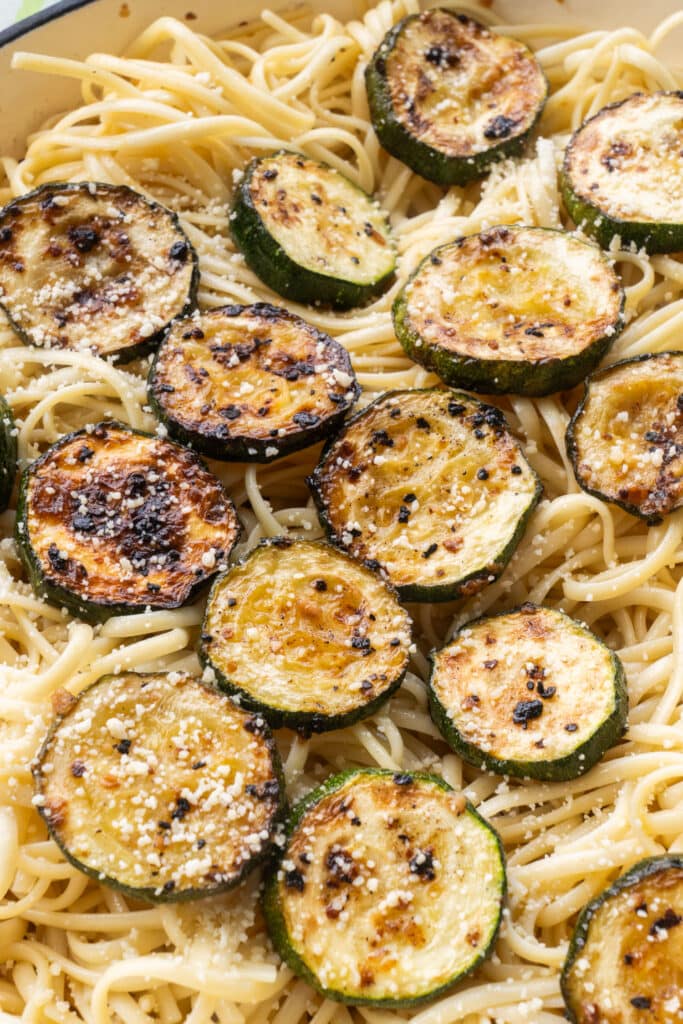 browned zucchini slices on linguini pasta.