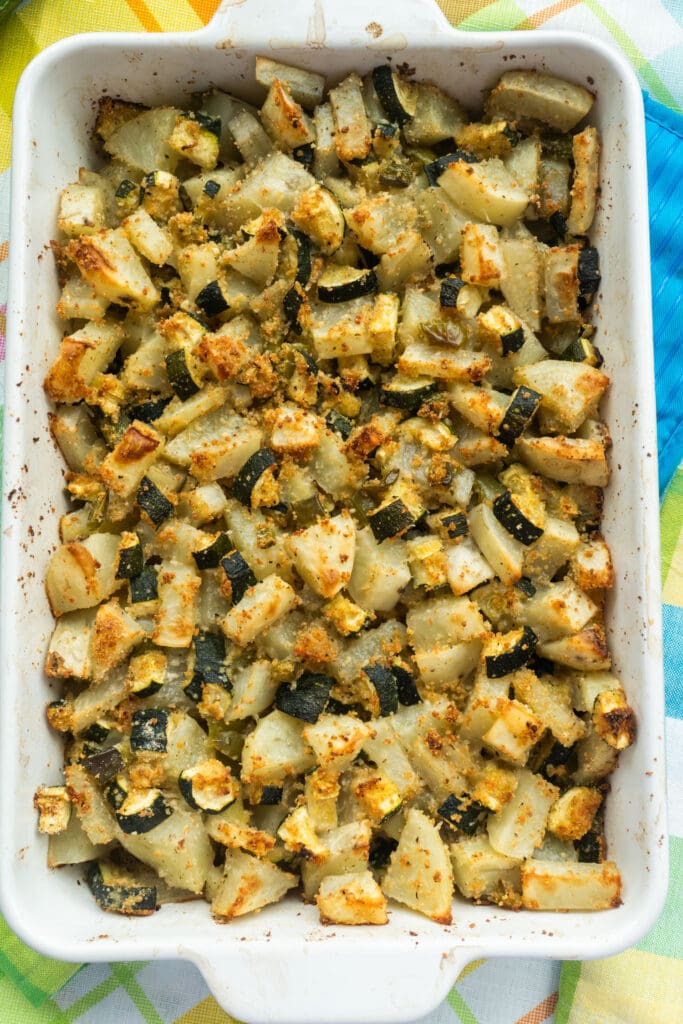 baked zucchini potato casserole in baking dish on table.