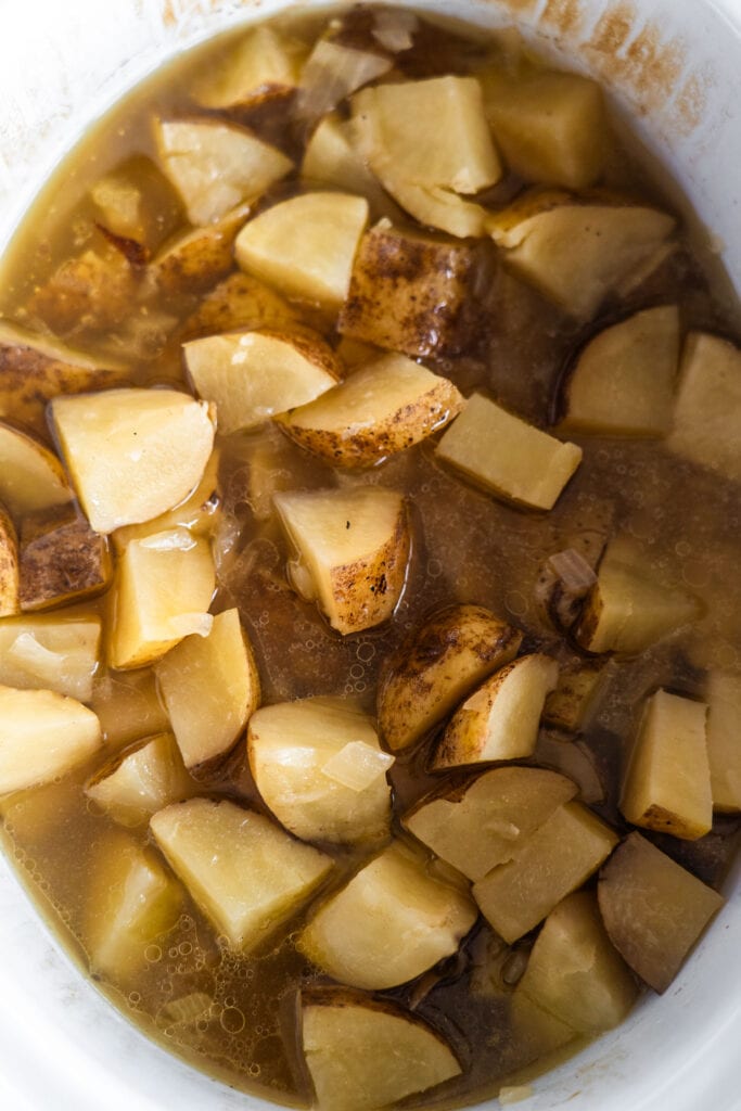 cooked potatoes and onions in slow cooker.