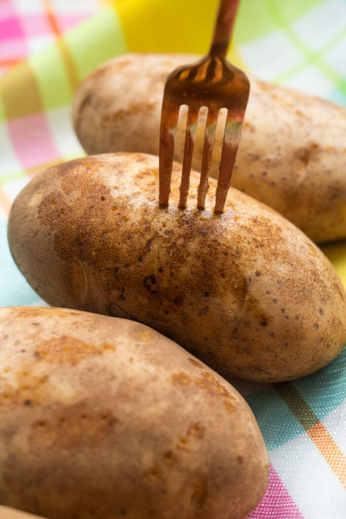 fork sliding into baked potato.