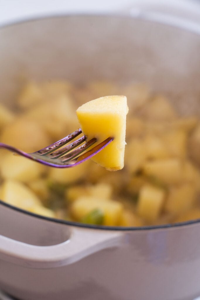 fork sliding into potato in pot.
