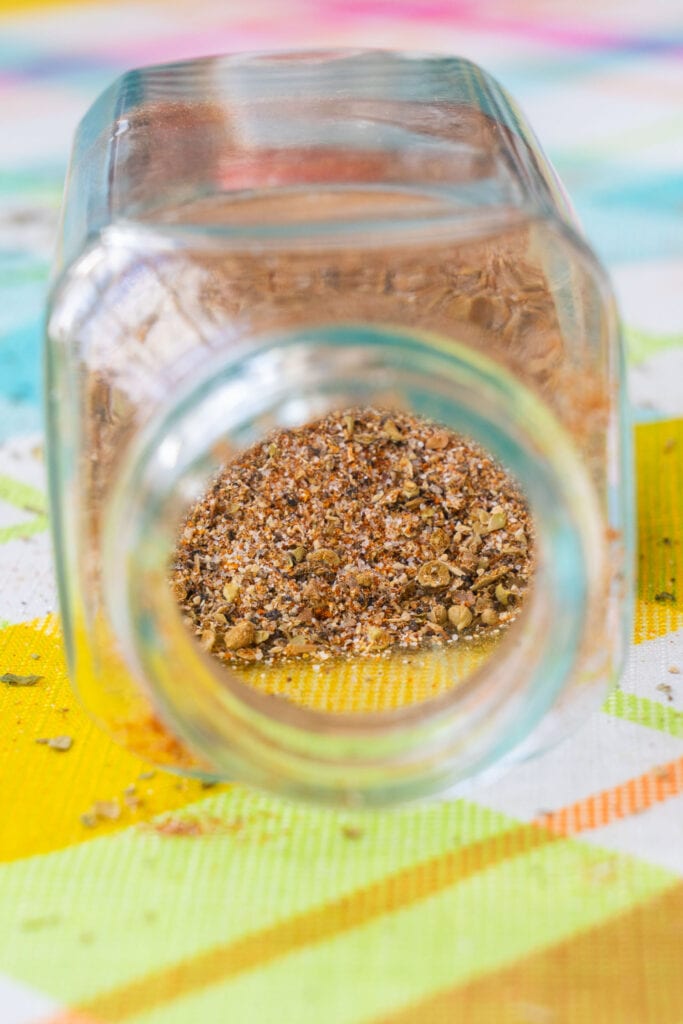 glass jar on side filled with adobo seasoning.