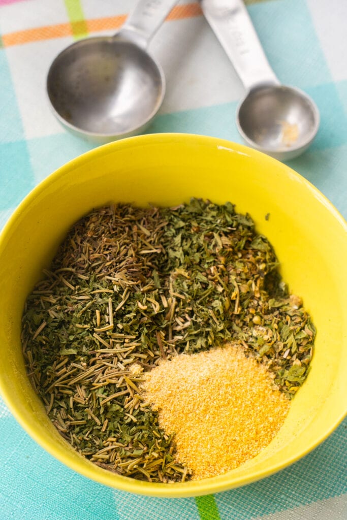 dried herbs in yellow bowl.
