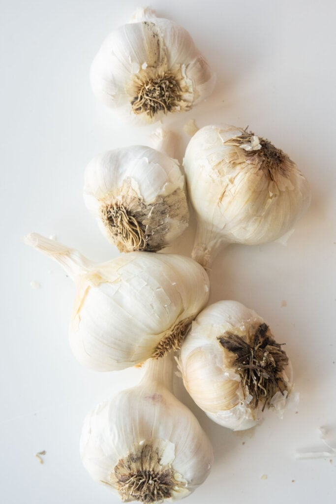 6 heads of garlic on table.