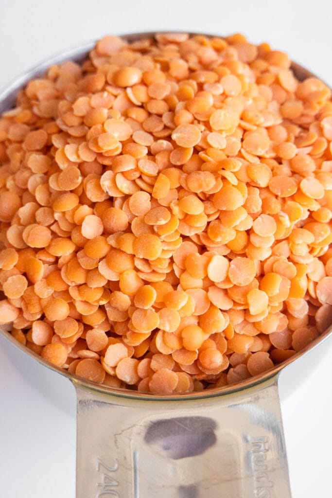 measuring cup filled with red lentils