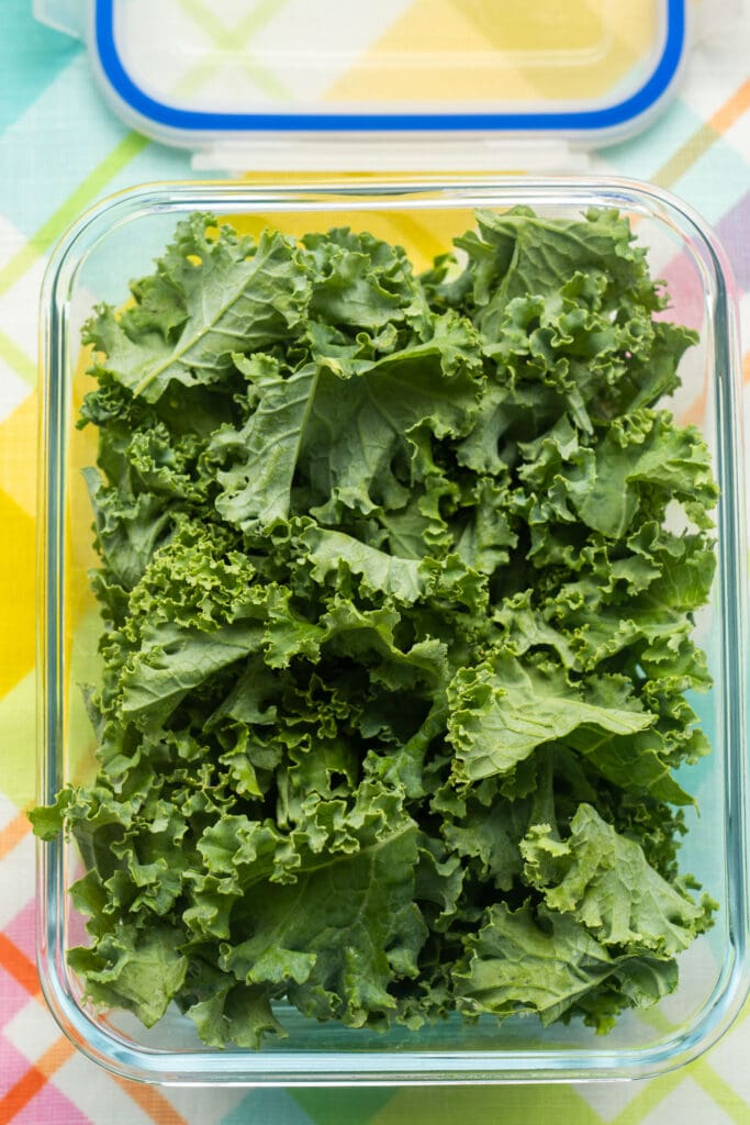 chopped kale being sored in glass container. 