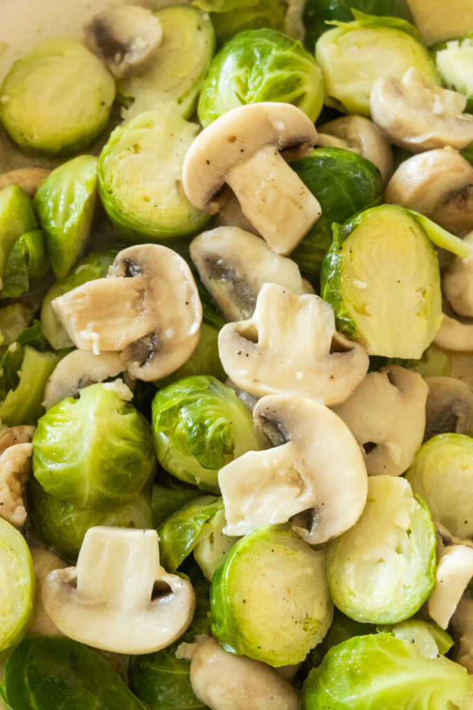 buttered brussels sprouts and mushrooms in skillet.