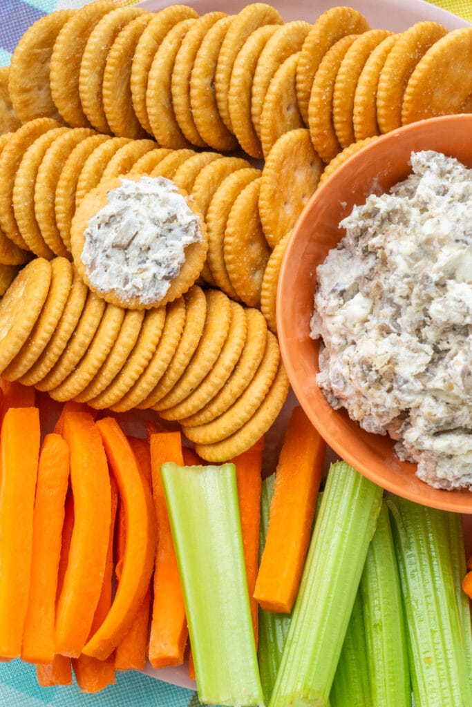 crackers and vegetables next to cream cheese dip.