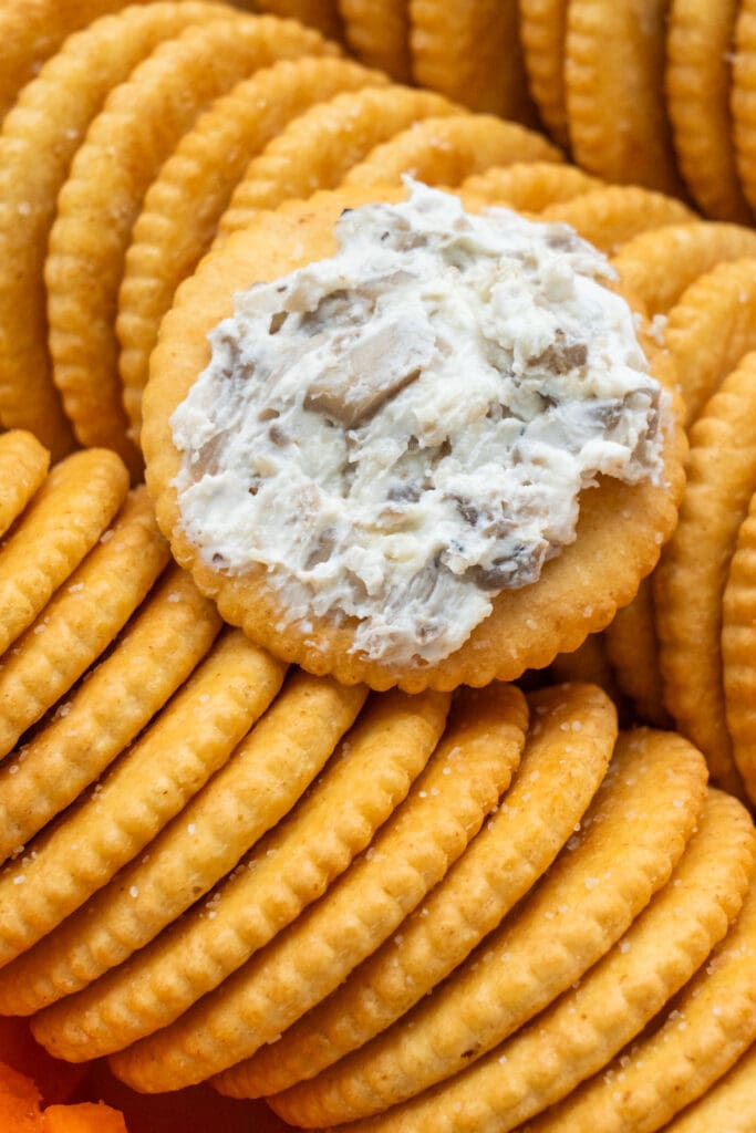 closeup of cracker with cream cheese mushroom dip on it.