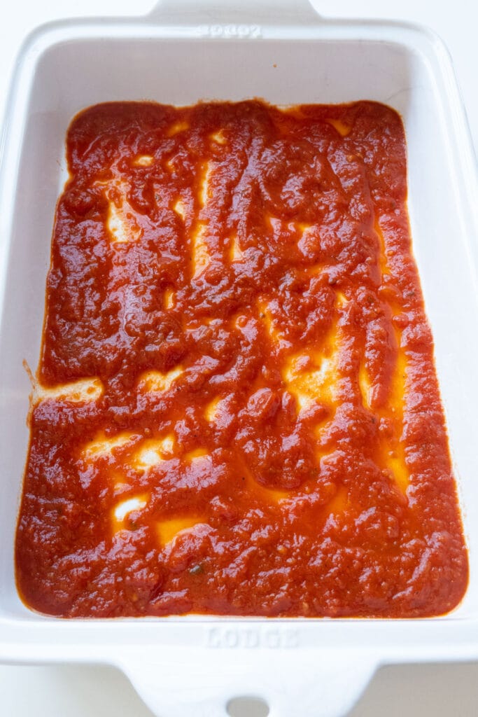 marinara sauce on bottom of baking dish.