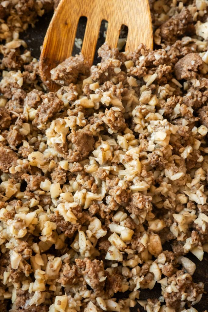 ground beef and mushrooms cooked together in skillet.